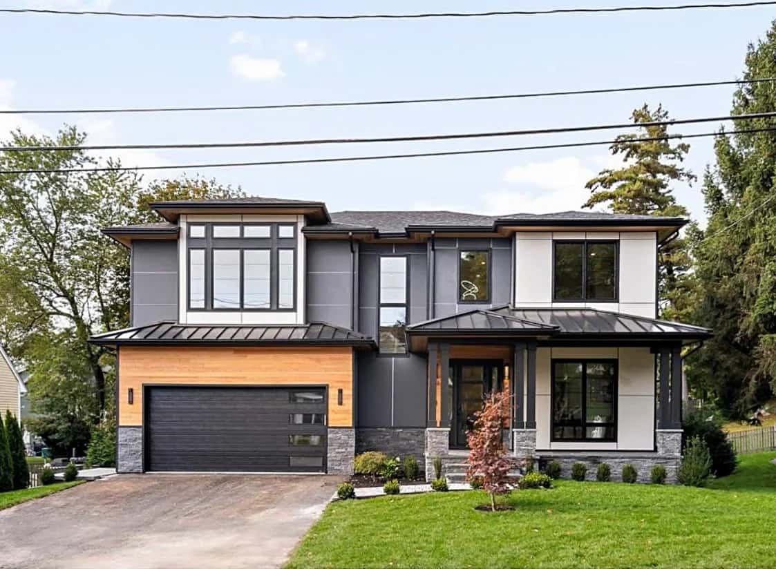 Completed contemporary home with a standing-seam metal roof and a wood-clad garage