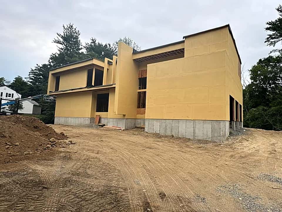 Modern two-story house with exterior sheathing on a graded lot