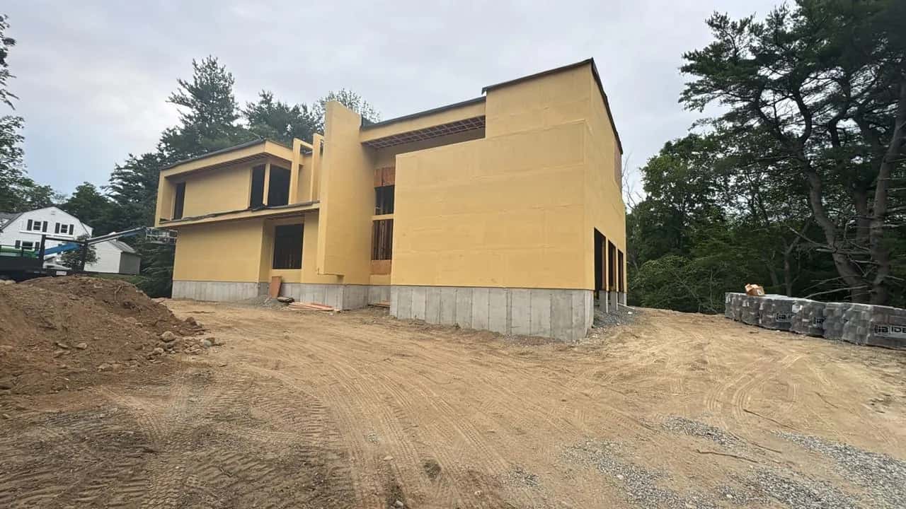 Modern two-story house with exterior sheathing on a graded lot
